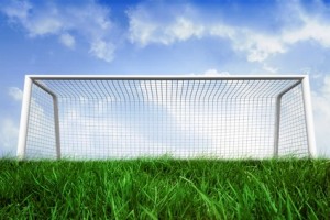 Goalpost on grass under blue sky